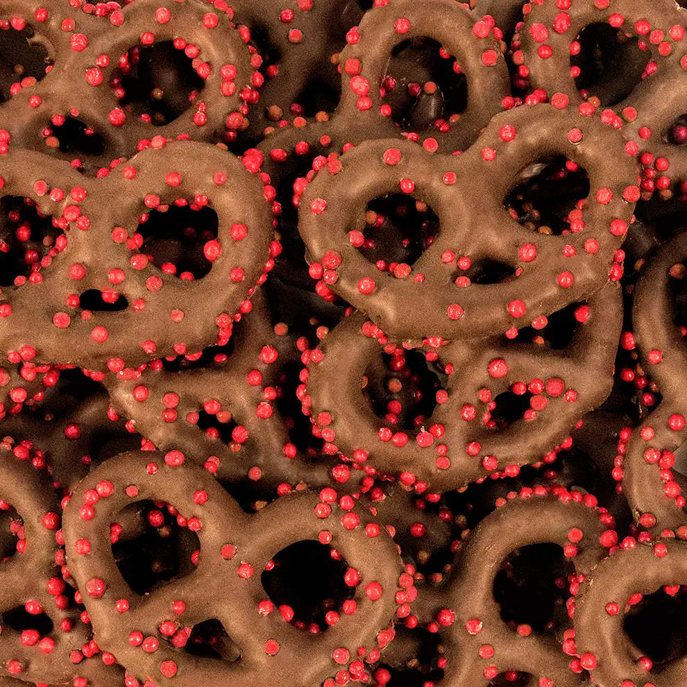 MILK CHOCOLATE PRETZELS W/ RED NON PAREILS